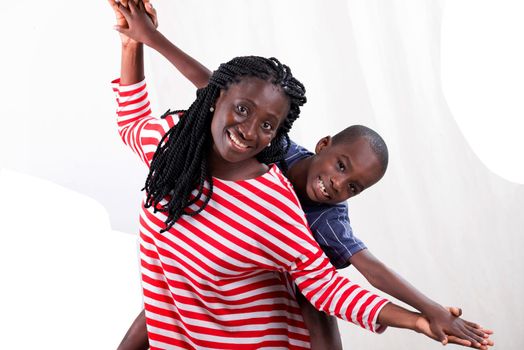 young happy mother carrying her child smiling on her back isolated on white background