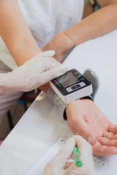 A girl doctor measures the blood pressure of an adult woman. The patient asked for help with high blood pressure. Health and medicine concept.
