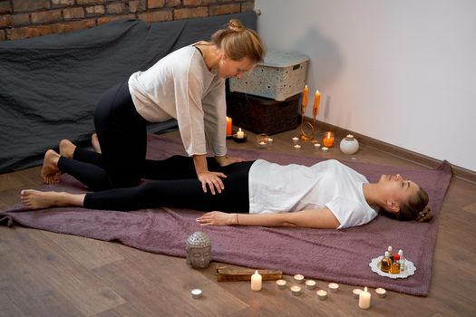 Relax and enjoy in spa salon getting thai massage by professional masseur Woman lying floor blanket Body care Hands treatment Acupressure trigger points Prevention muscles pain stretching flexibility