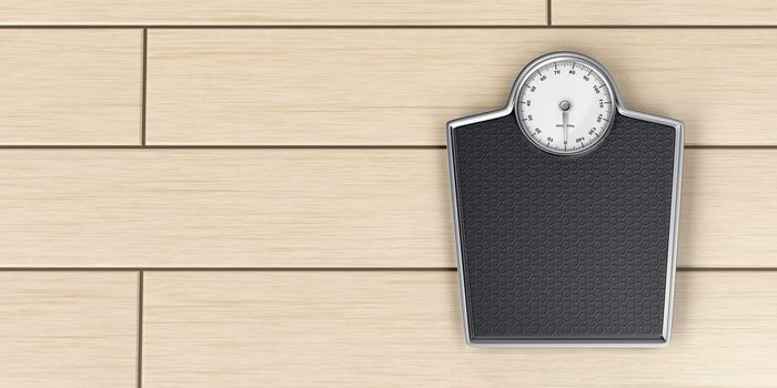 Mechanical weighing scale on wood floor, top view