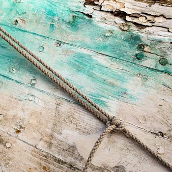 Old and colored boat wooden hull, old painting with green and white cracks and wood texture