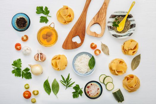 Italian foods concept and menu design. Various kind of Pasta with wooden spatula set up on white wooden background with flat lay.