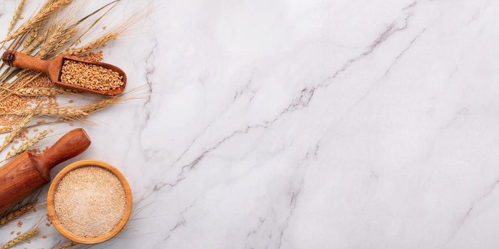 Wheat ears and wheat grains set up on marble background. Top view and copy space