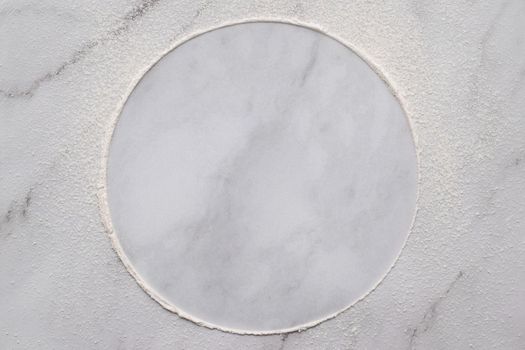 Scattered wheat flour on white marble background. Sprinkled wheat flour circle on white background.