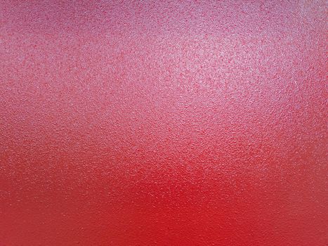 full frame bacground of red shagreen powder paint coating on flat sheet steel surface, industrial grade equipment coating