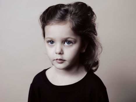 Close up headshot portrait of smiling little girl isolated on grey studio background