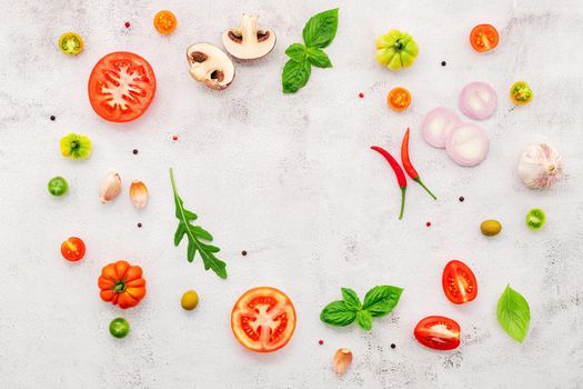 The ingredients for homemade pizza set up on white concrete background.