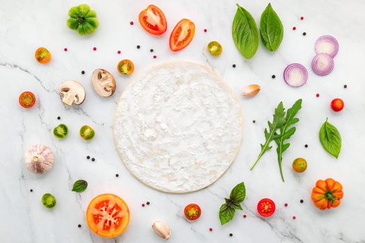 The ingredients for homemade pizza set up on white marble background with copy space and top view.