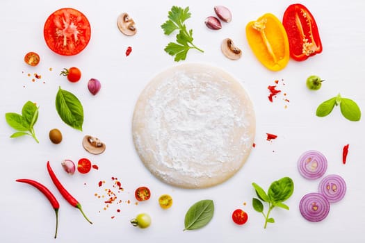 The ingredients for homemade pizza on white wooden background.