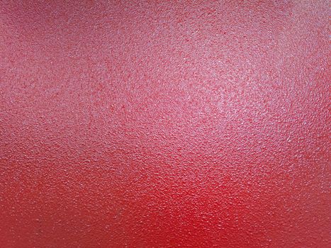 full frame bacground of red shagreen powder paint coating on flat sheet steel surface, industrial grade equipment coating