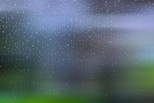 Small raindrops on a window with a green and blue blurred background. Abstract illustration