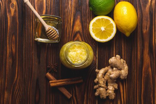 Ginger, lemon, honey, cinnamon on a dark wooden background. Cold cure recipe and healthy food