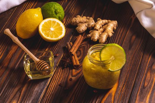 Ginger, lemon, honey, cinnamon on a dark wooden background. Cold cure recipe and healthy food