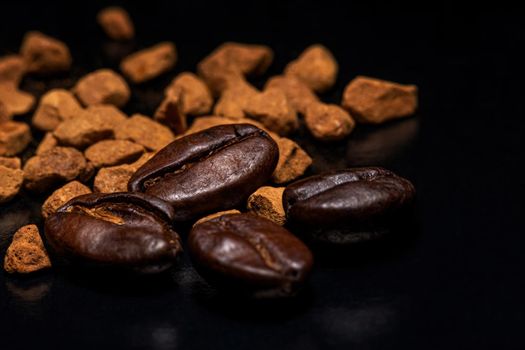 Coffee beans and instant coffee granules on a dark background, macro, close-up