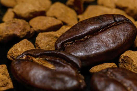Coffee beans and instant coffee granules on a dark background, macro, close-up