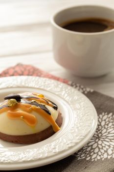 Still life with a cup of coffee and sweet cake on white wooden table. Breakfast in the morning sun