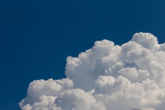 Huge cumulonimbus high in the deep blue sky