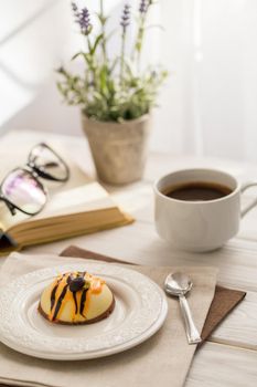 Still life with coffee, cake and a bouquet of lavender on white wooden table. Breakfast in the morning sun