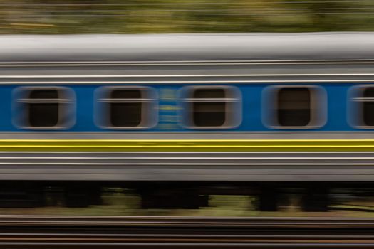 Railroad train high dynamic motion blur, abstract blurred background with green trees, side view