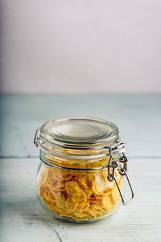 Jar full of corn flakes on a wooden surface