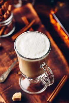 Irish coffee with cinnamon on wooden surface