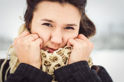 girl in warm clothes and scarves on a walk in the snowy forest and in the field