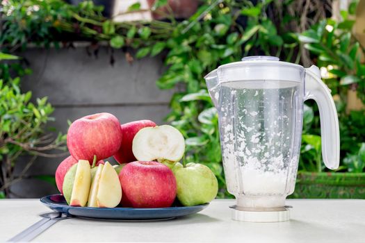 Group of apples and guavas fruits in the ceramic plate for make fresh apple and guava juice with an electric blender.