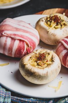 Preparing of bacon-wrapped button mushrooms stuffed with grated cheddar cheese and spices