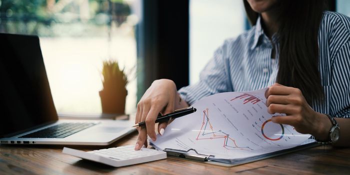 Fund managers researching and analysis Investment stock market by paperwork on wooden desk in office