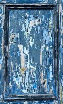 The door panel is heavily weathered and shows various layers of paint through to the wood.