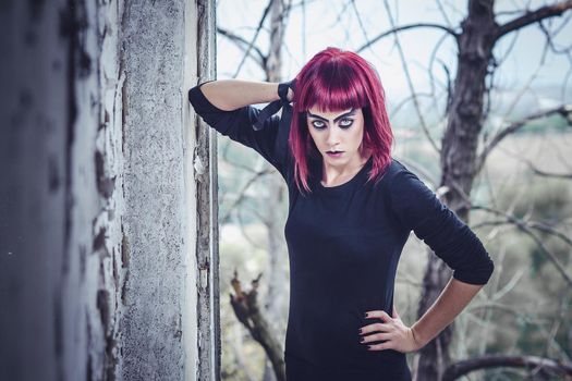 girl model in black with pink hair in an abandoned building