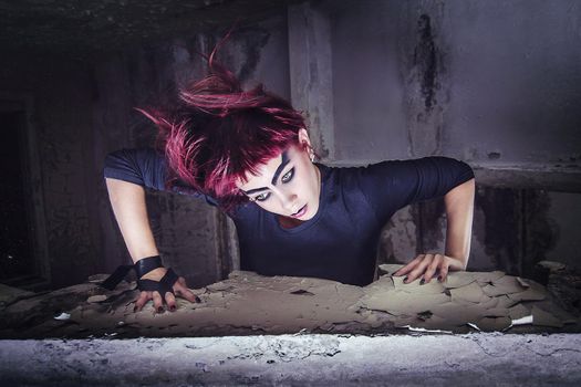 girl model in black with pink hair in an abandoned building