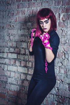 girl model in black with pink hair in an abandoned building