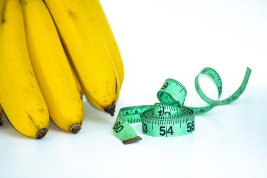 Bunch of banana with measuring tape isolated on white - Diet concept