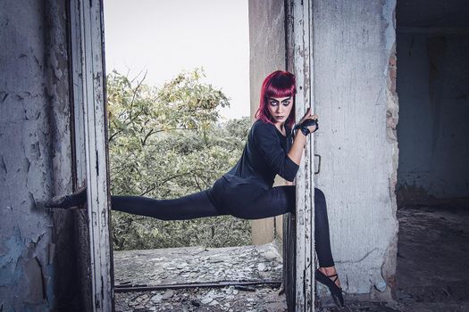 girl model in black with pink hair in an abandoned building