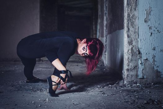 girl model in black with pink hair in an abandoned building