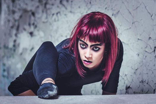 girl model in black with pink hair in an abandoned building