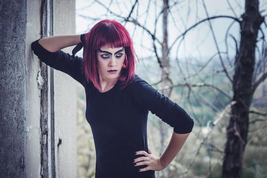 girl model in black with pink hair in an abandoned building