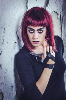 girl model in black with pink hair in an abandoned building