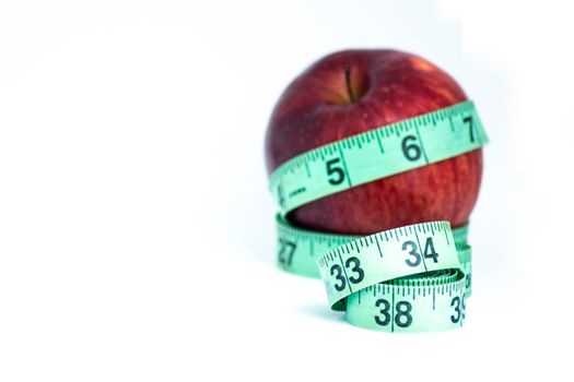 Blurred red apple with measuring tape isolated on white - Diet concept