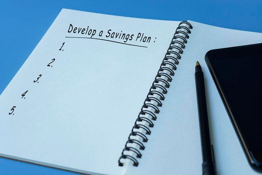 Develop a savings plan text on notepad with blue background