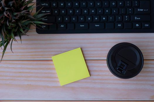 Yellow note on wooden table. Space for text. Flat lay, top view