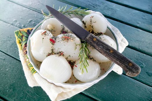 Photographic shot of the presentation of a dish of boiled white onions with a rosemary and chili flavor 