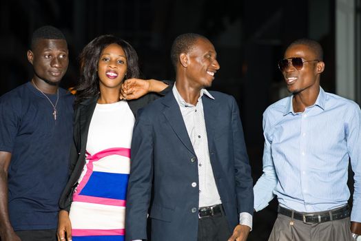 smiling group of business people standing outside in late evening