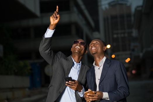 Meeting of businessmen standing outdoors in the evening after work and looking over them