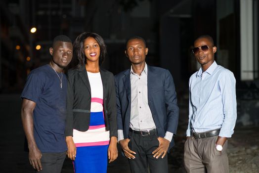 smiling group of business people standing outside in late evening