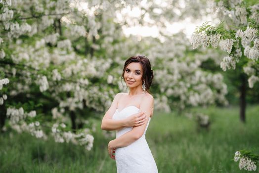 bride in a white dress with a large spring bouquet in a green forest