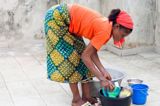 young african american woman doing the dishes in the yard of the house