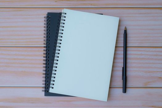 Note book with pen on wooden table. Space for text. Flat lay, top view