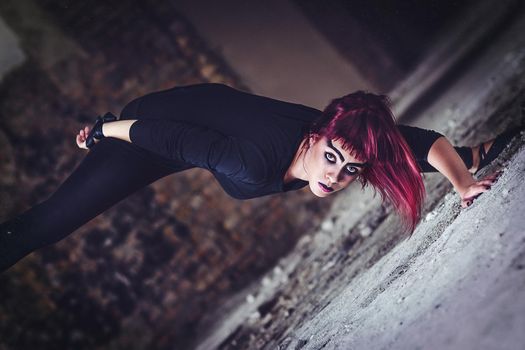 girl model in black with pink hair in an abandoned building